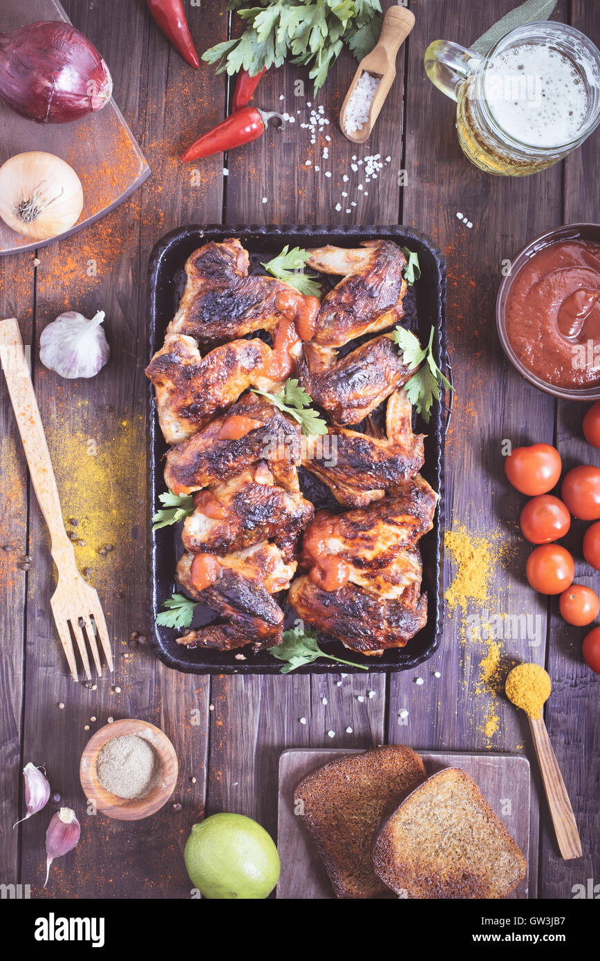 Oven-roasted spicy chicken wings on serving pan Stock Photo