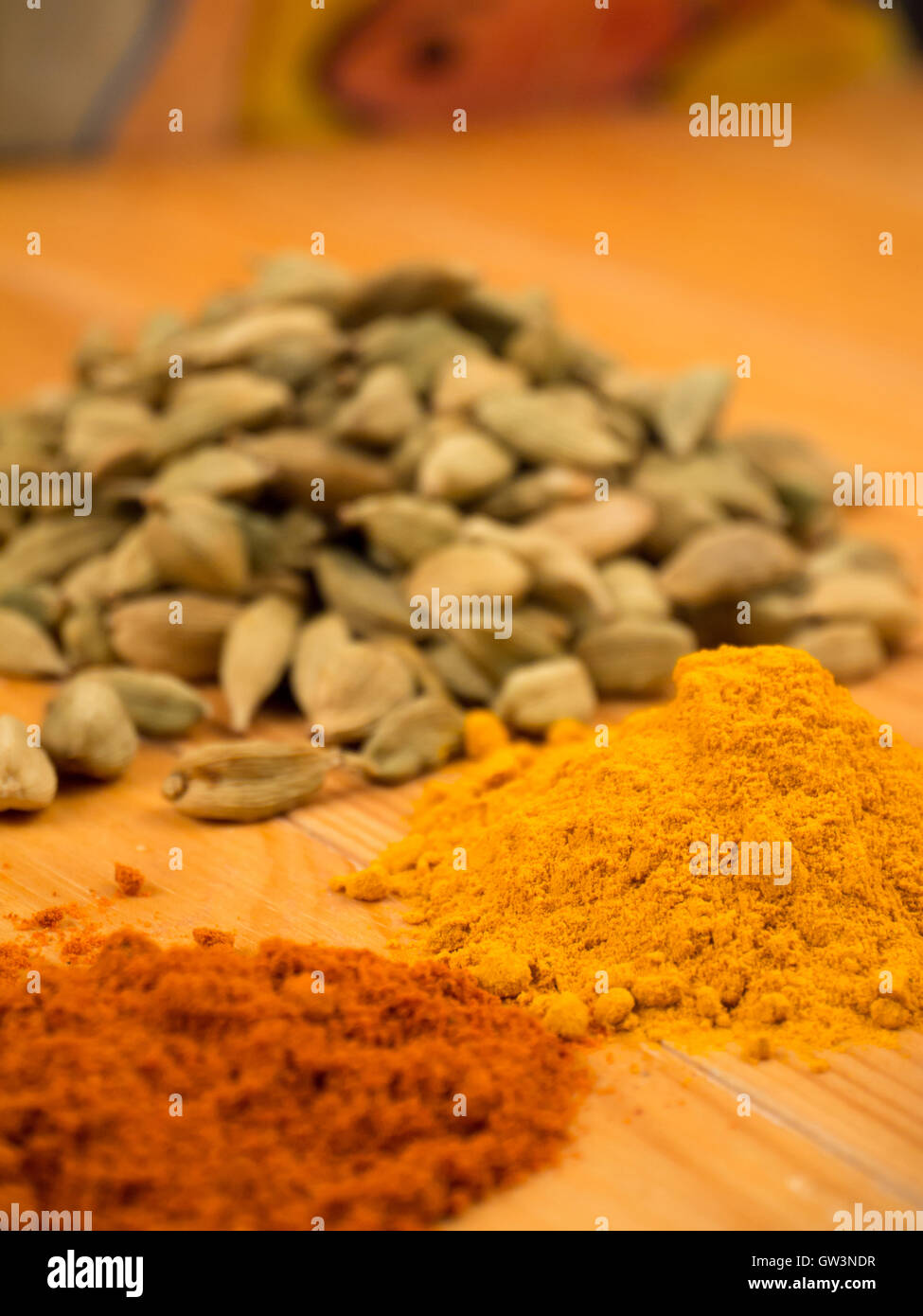 Colorful cardamon,  turmeric and pepper piles on the blurred background Stock Photo