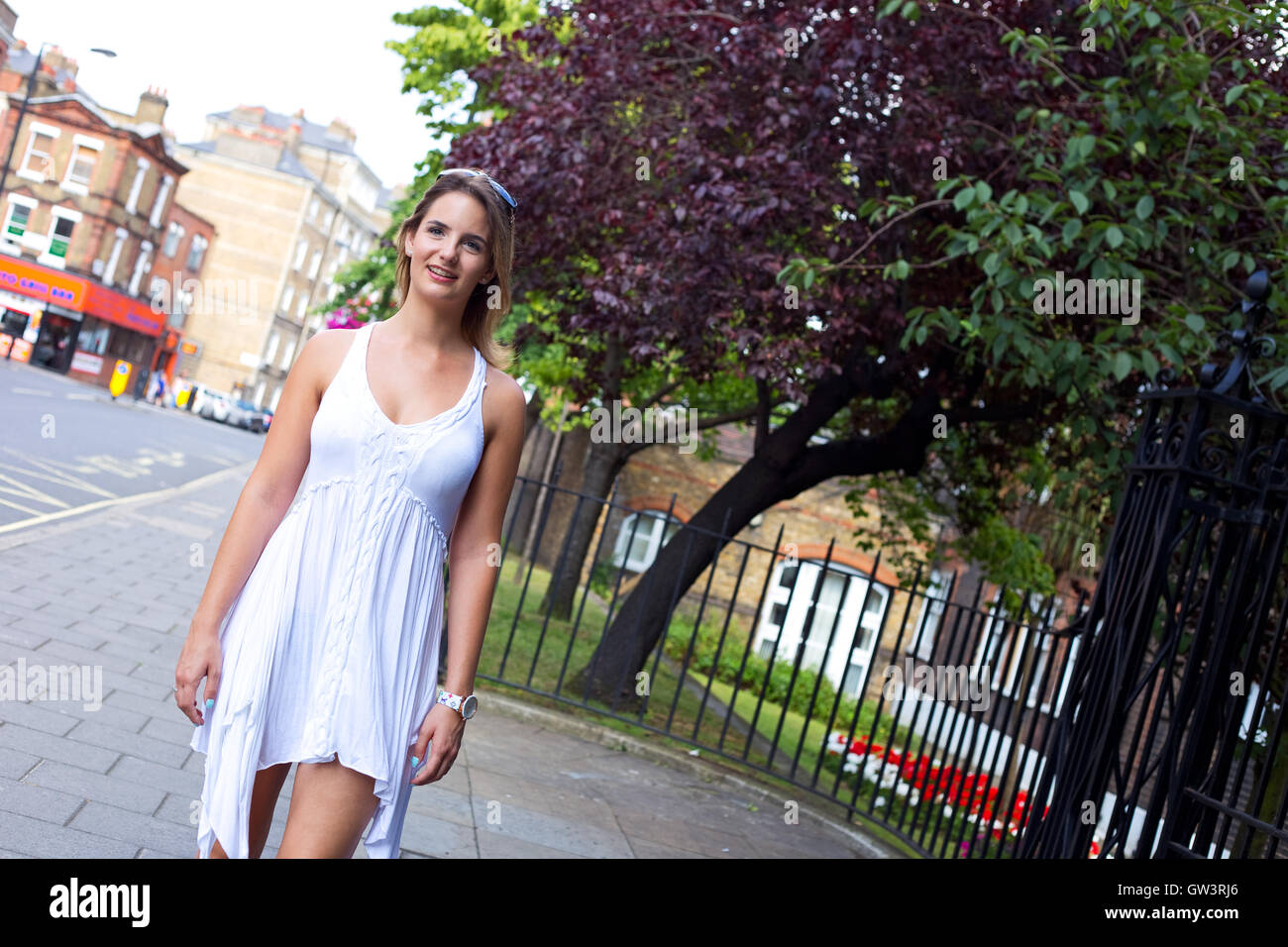 beautiful girl walking in the street wearing a summers dress Stock Photo