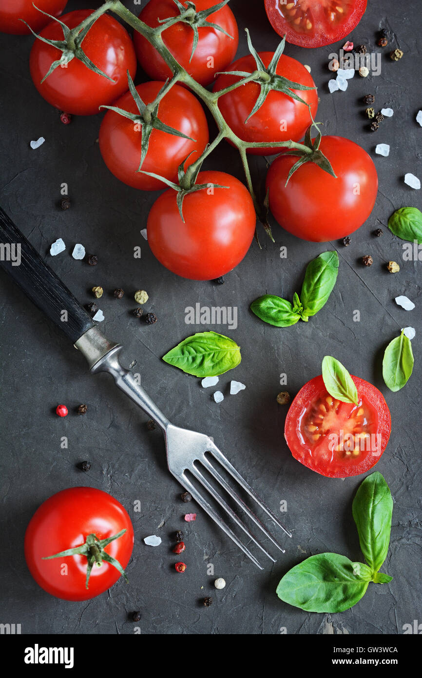 Fresh cherry tomatoes and basil on a black slate Stock Photo - Alamy