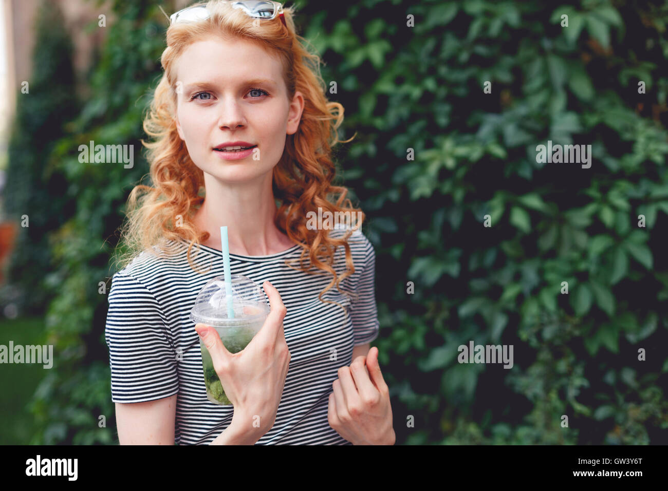Ginger girl with curly hair and cocktail , tinted photo Stock Photo Alamy