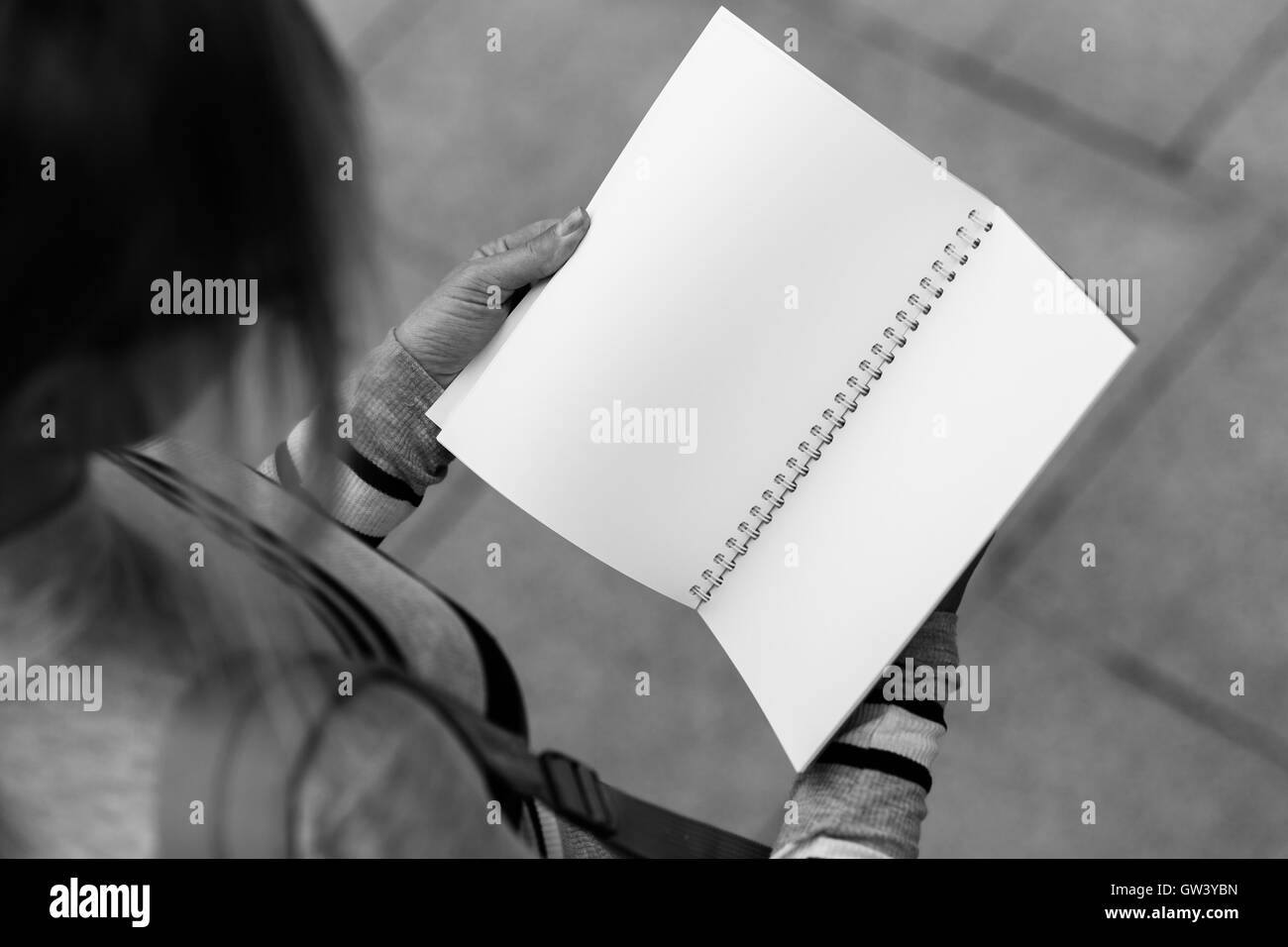 Girl holds open notebook, top view,black and white photo Stock Photo