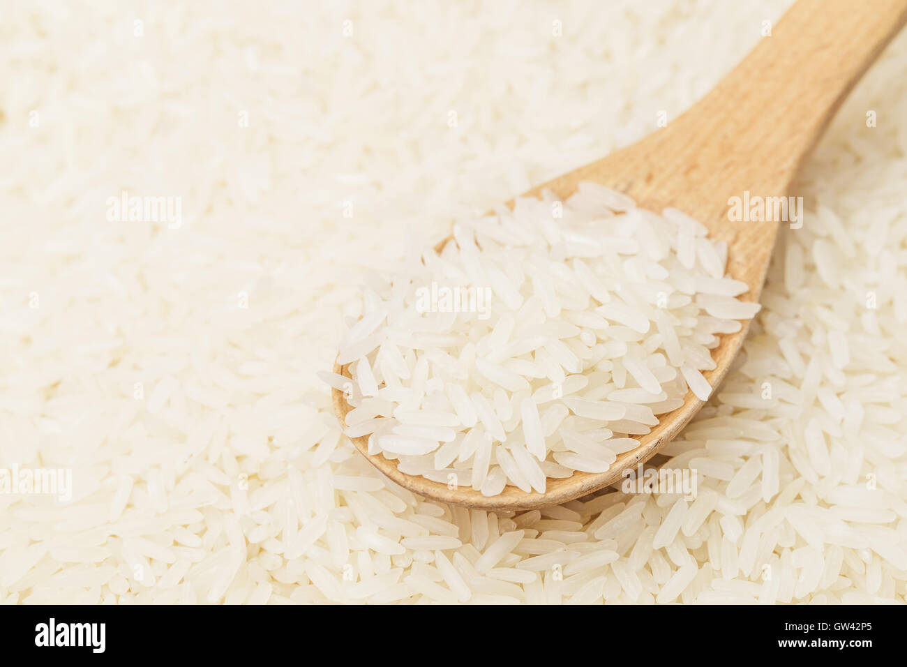 Uncooked white rice with spoon Stock Photo Alamy