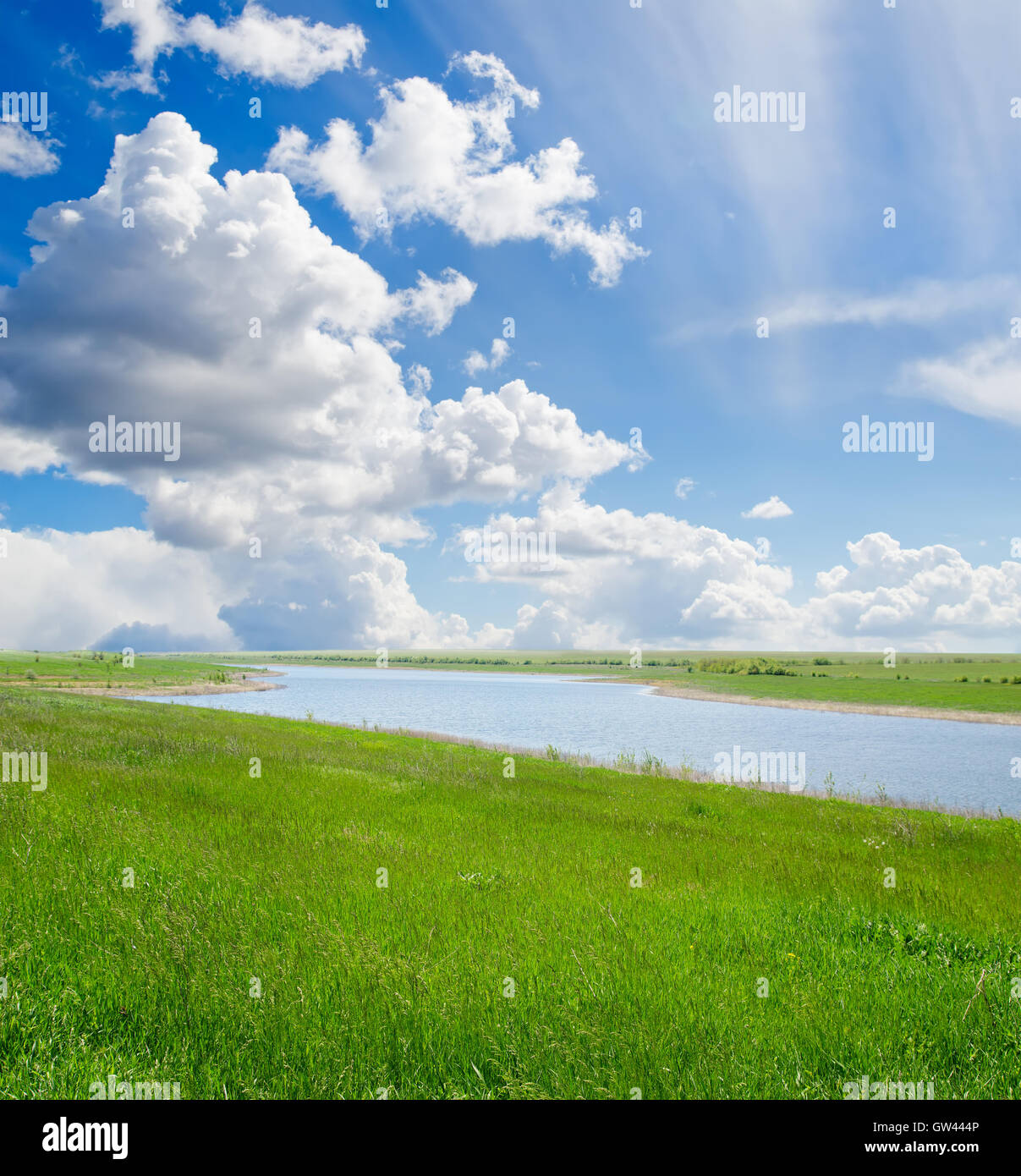 green grass and cloudy sky with river Stock Photo - Alamy