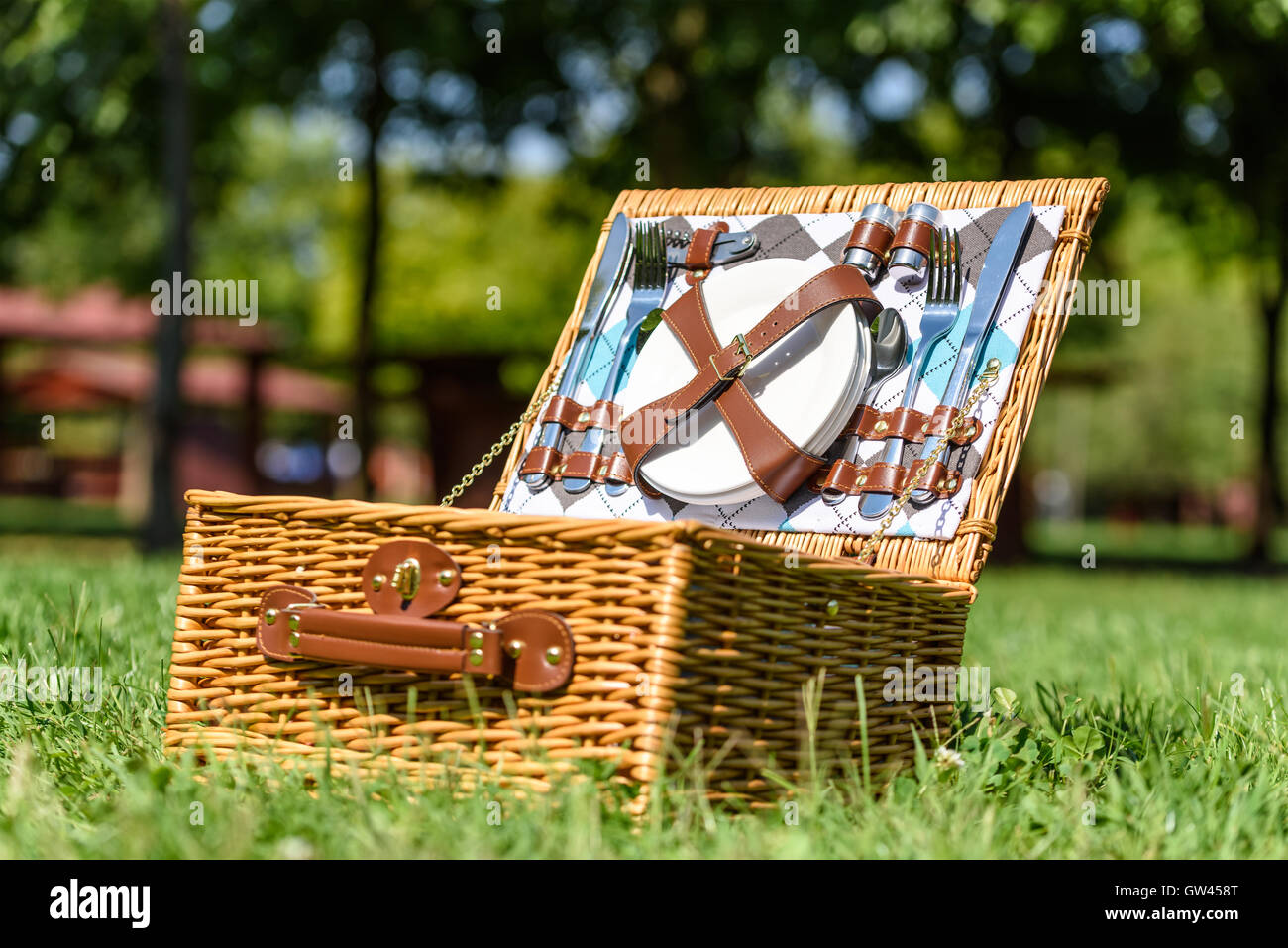 Opened Picnic Basket With Cutlery In Spring Green Grass Stock Photo