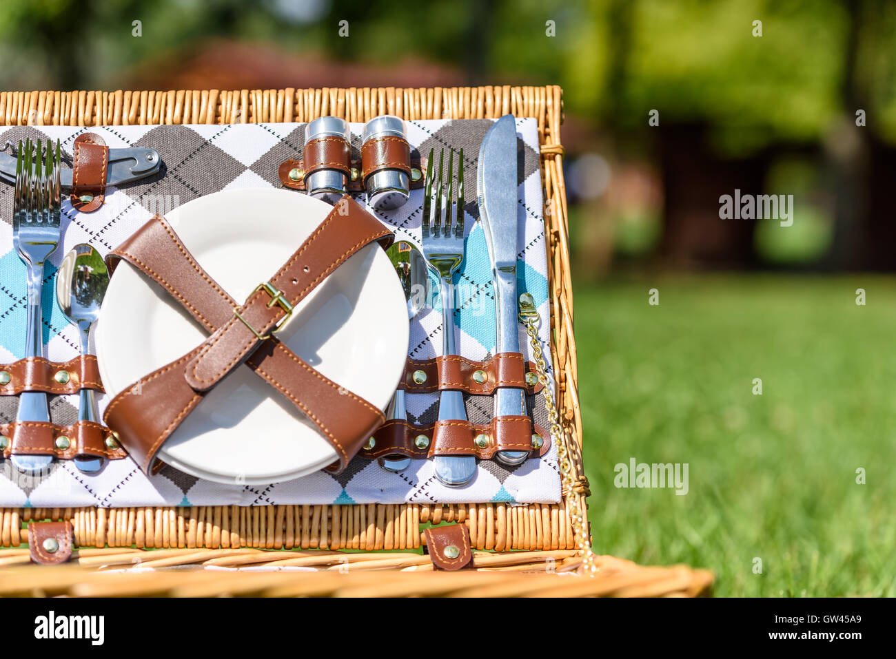Opened Picnic Basket With Cutlery In Spring Green Grass Stock Photo