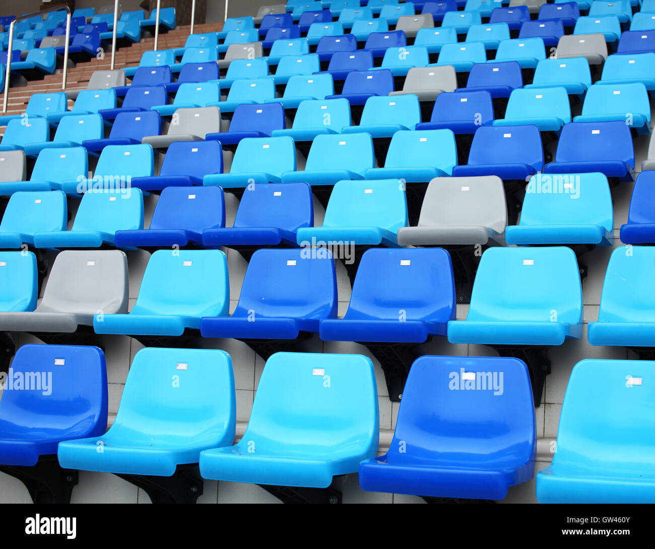 blue plastic old stadium seats on concrete steps Stock Photo