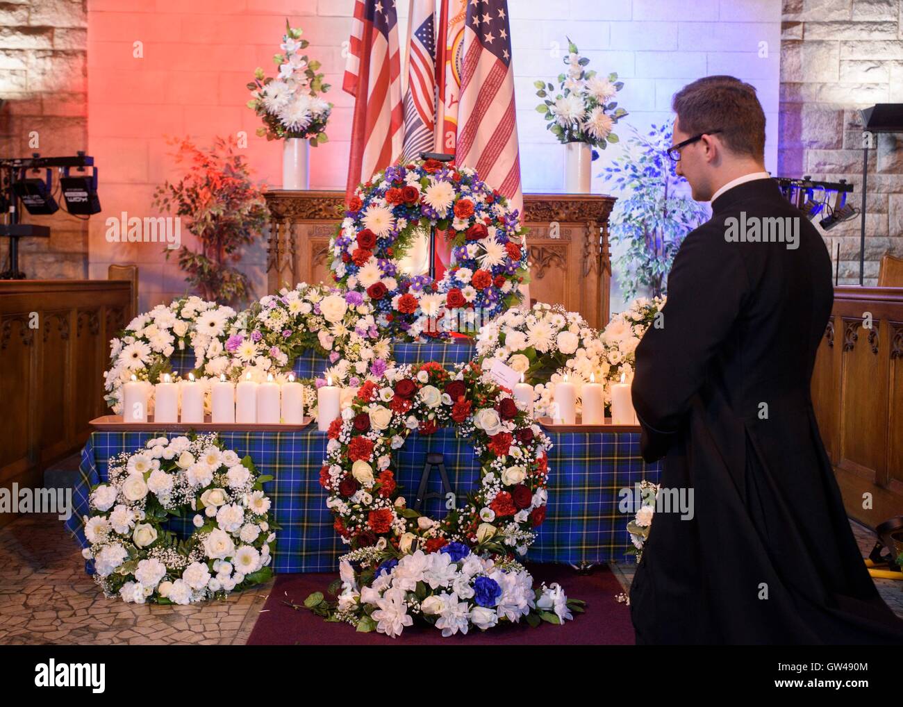Polish Catholic Priest Maximillian MacAulay looks at the wreaths during a special memorial service to mark the 15th anniversary of 9/11 at Cathcart Old Parish Church, Glasgow. Stock Photo