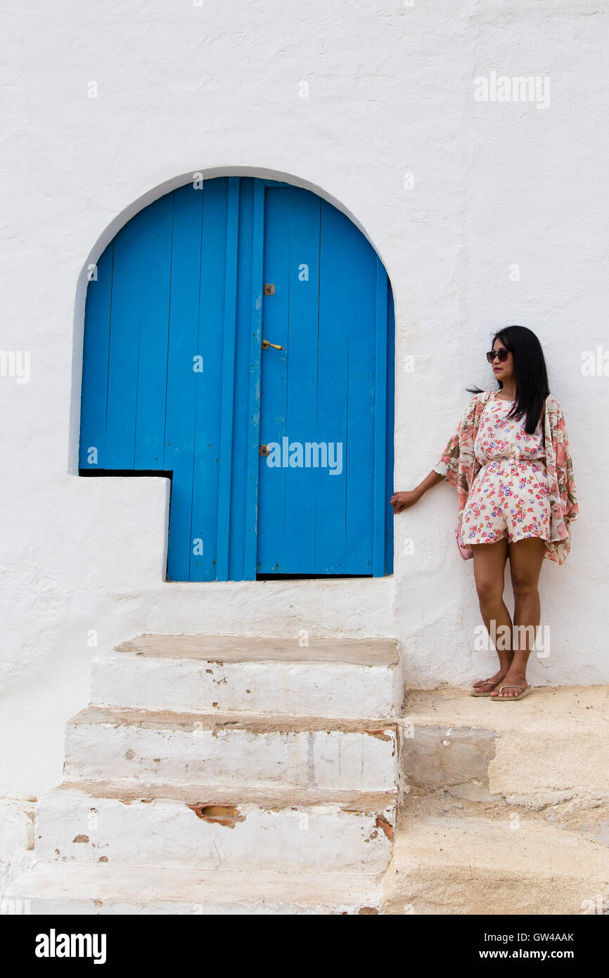 girl standing by blue door Stock Photo