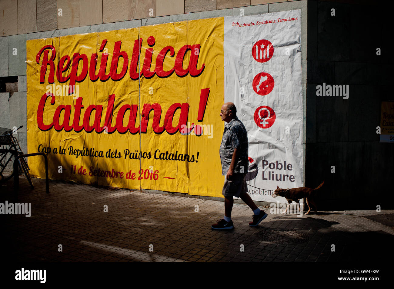 Barcelona, Catalonia, Spain. 11th September, 2016. A man and his dog passing by a banner that reads  Catalan Republic during the celebration of the National Day of Catalonia or 'La Diada'  in Barcelona. Credit:   Jordi Boixareu/Alamy Live News Stock Photo
