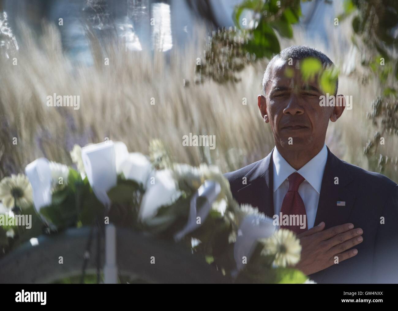 U.S President Barack Obama salutes after placing a wreath at the Pentagon Memorial at a remembrance ceremony commemorating the 15th anniversary of the 9/11 terrorist attacks at the Pentagon September 11, 2016 in Arlington, Virginia. Stock Photo