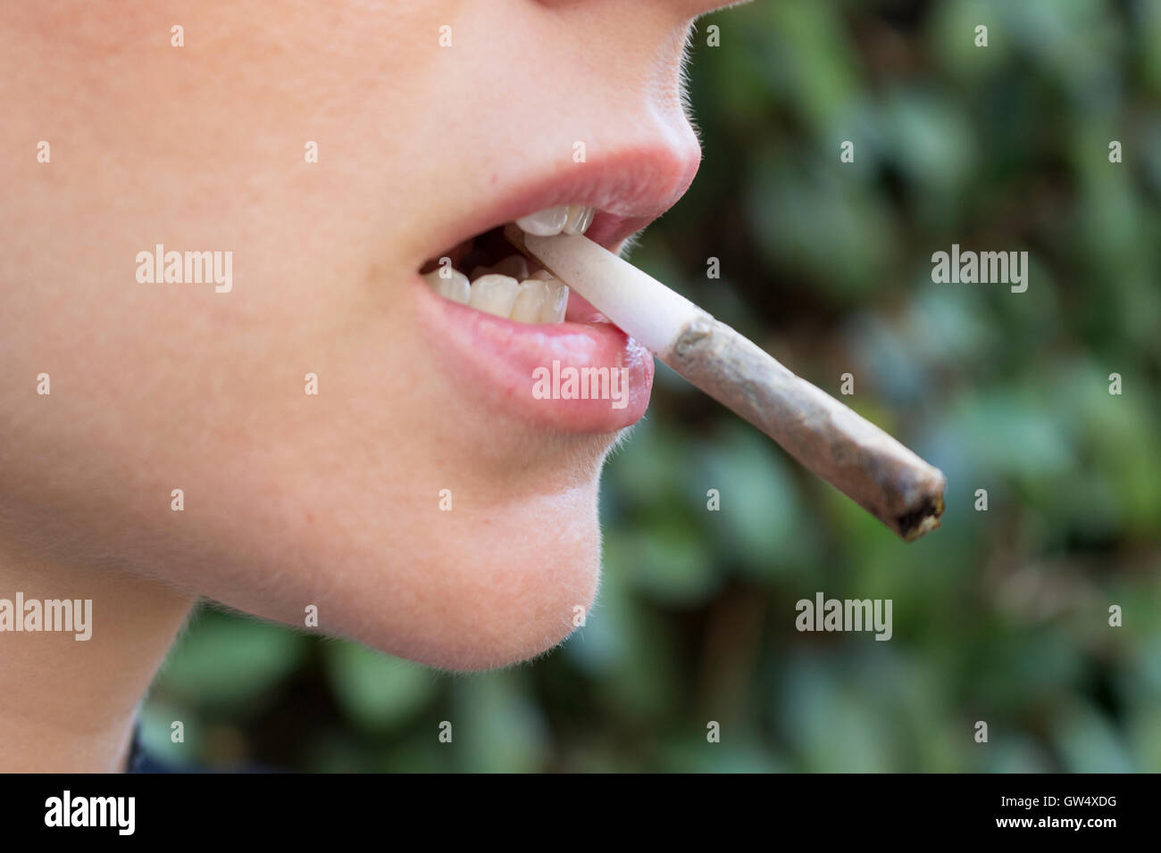 Woman With a Marijuana Joint in Her Mouth Stock Photo