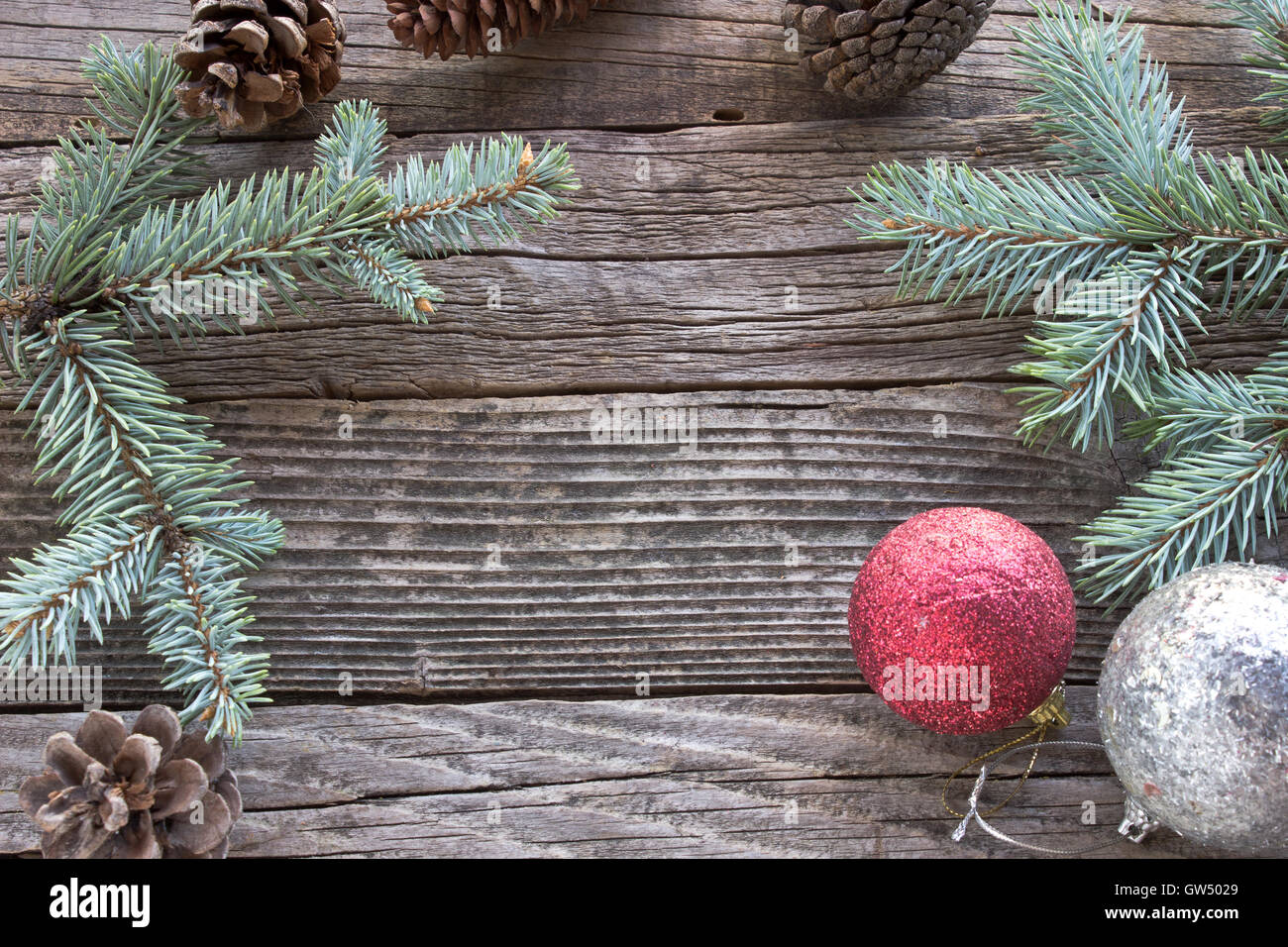 Pine cones, needles and Christmas balls on wooden background Stock Photo