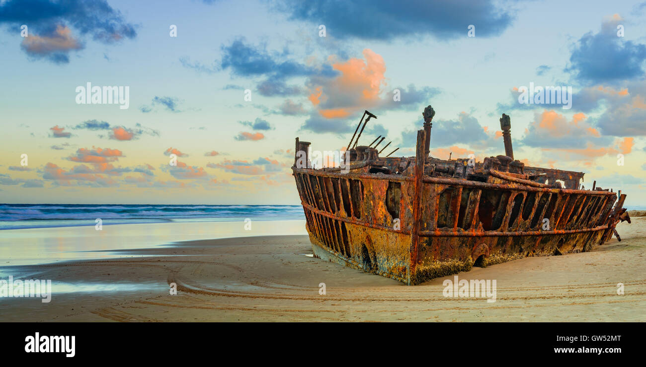 The shipwrecked Maheno at sunset on Fraser Island as the setting sun turns the clouds pink Stock Photo