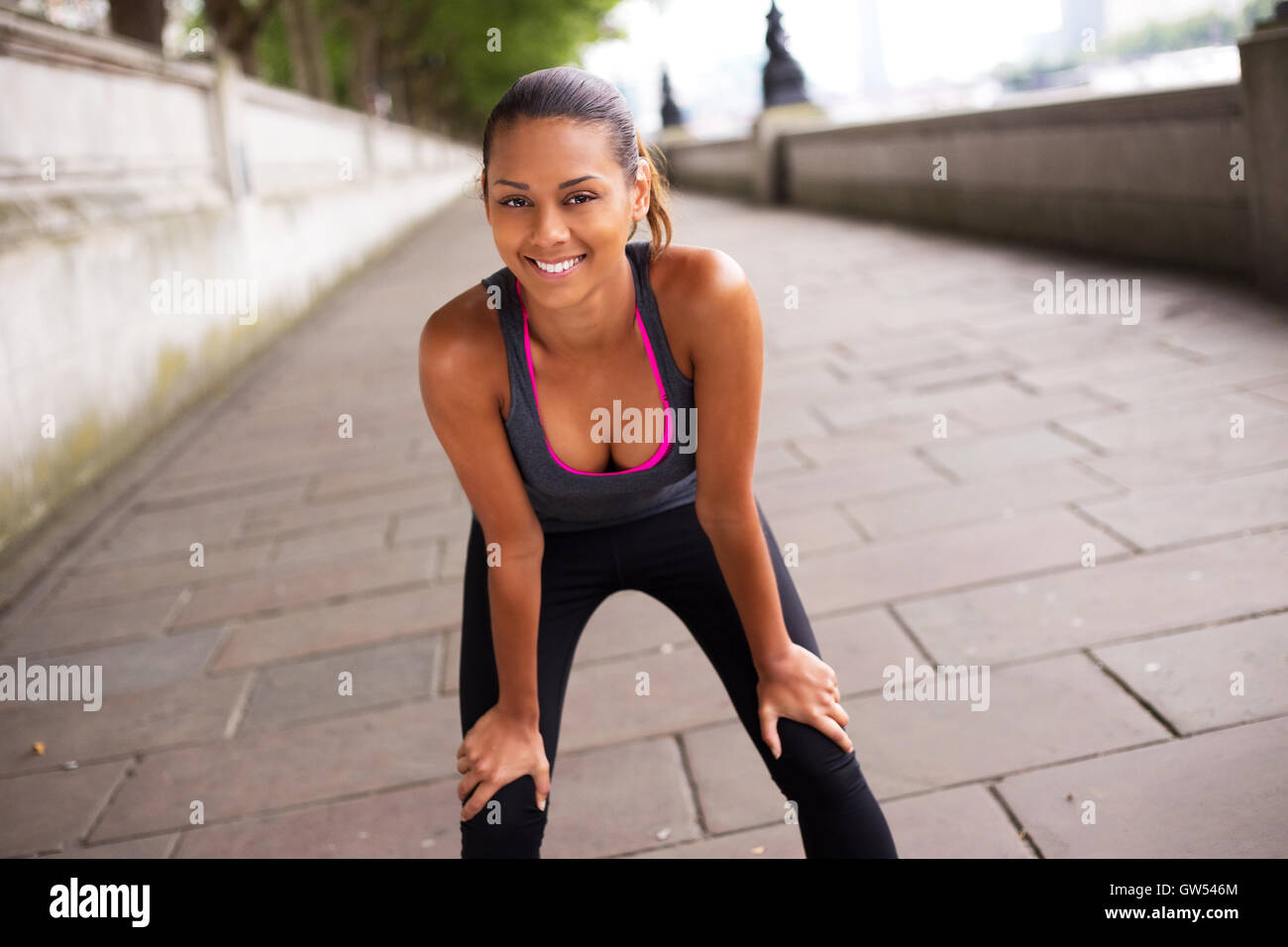 young woman catching her breath while exercising Stock Photo