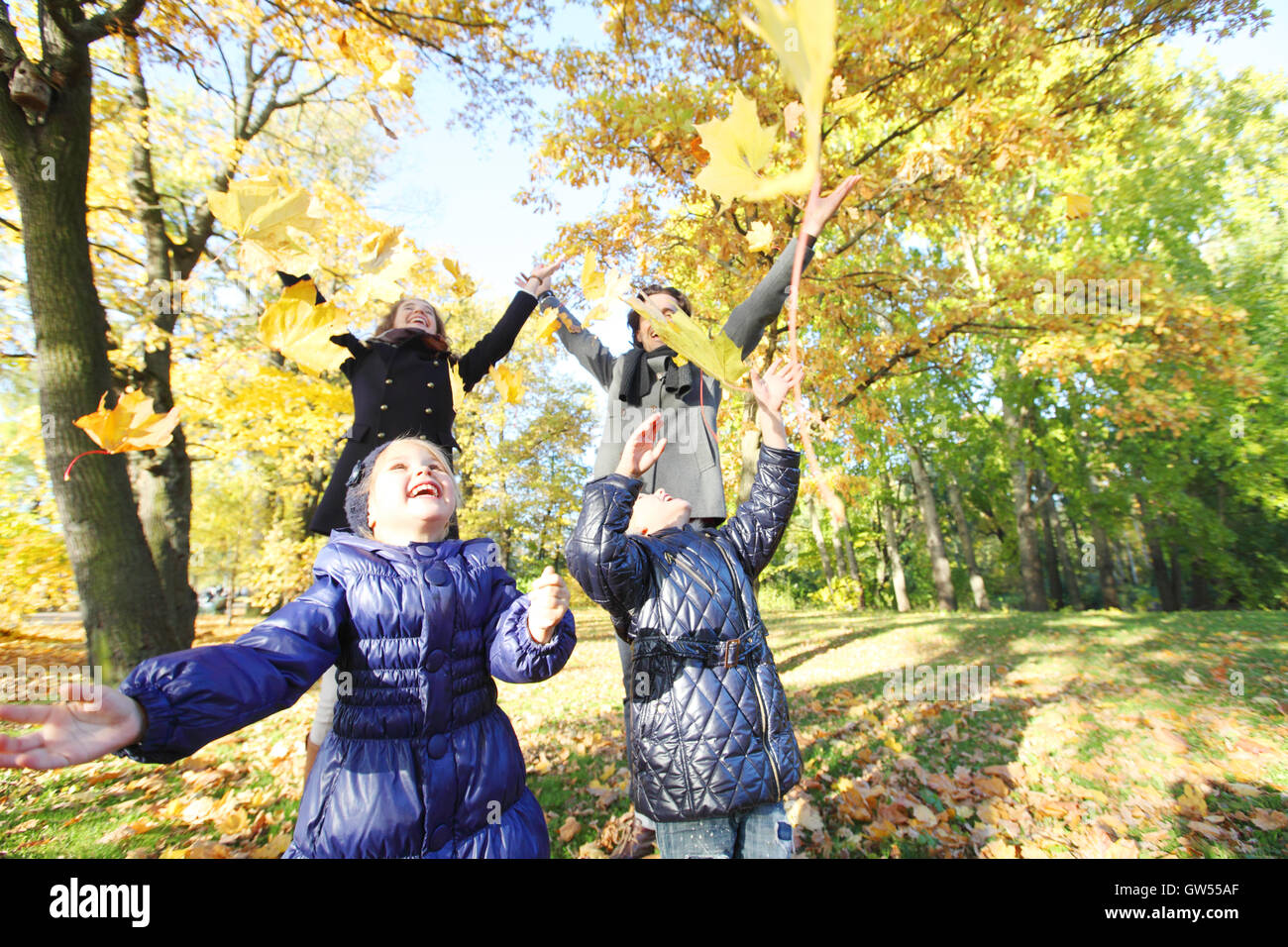 Happy family playing with autumn maple leaves in park Stock Photo - Alamy