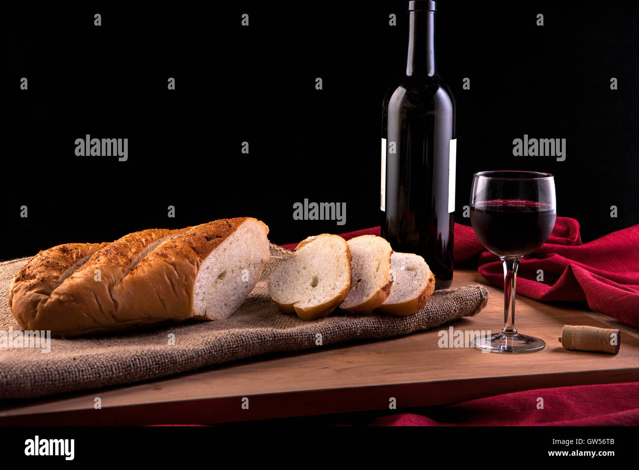 Slices from a loaf of french bread and an wine glass and wine bottle. Stock Photo
