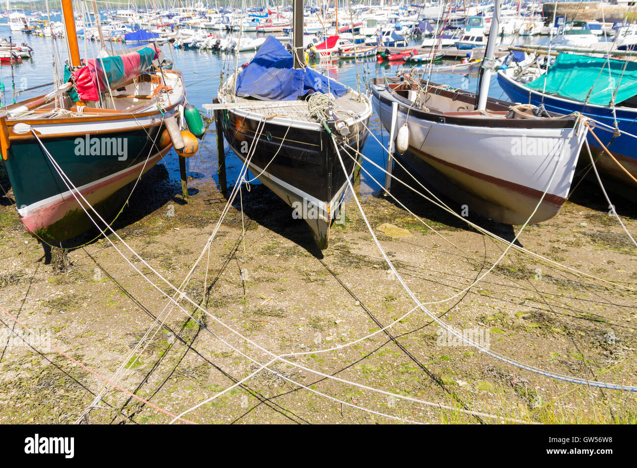 Old fishing boats tied up at low tide in Mylor Harbour Cornwall Stock