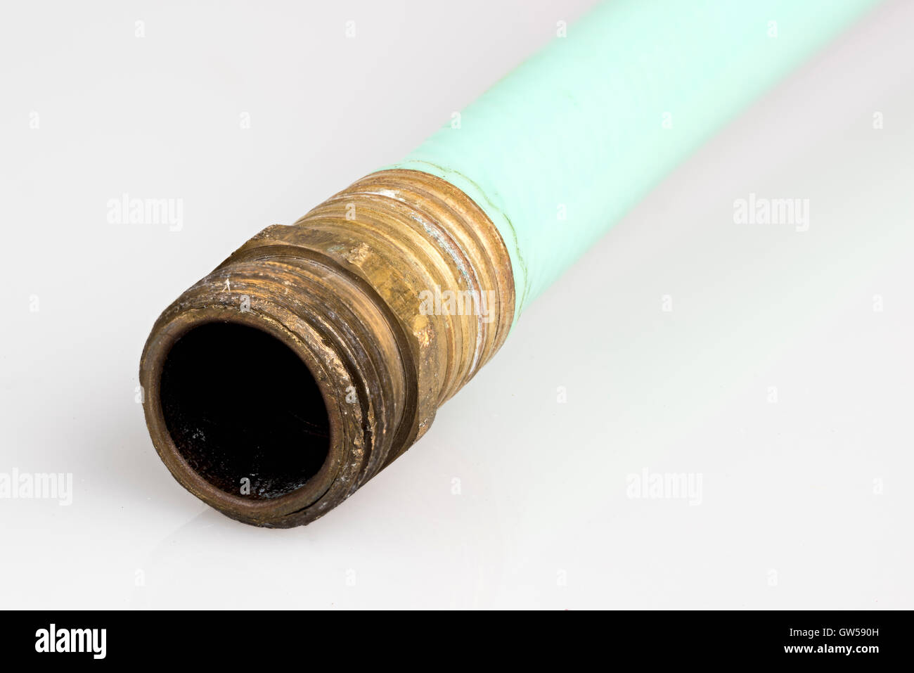 Old garden hose with brass fitting Stock Photo