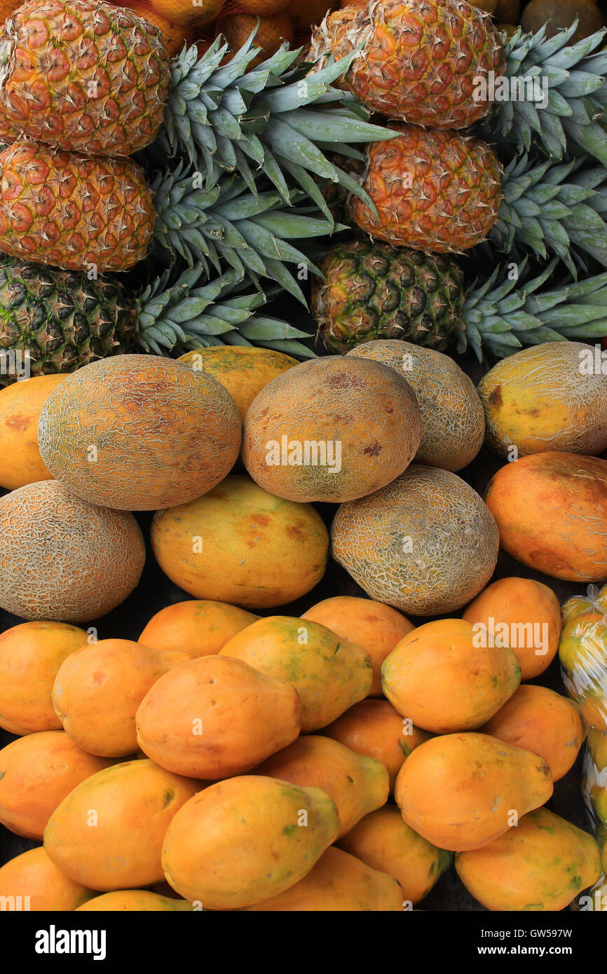 Fresh pineapples, melons and avocados for sale at the outdoor food market in Otavalo, Ecuador Stock Photo
