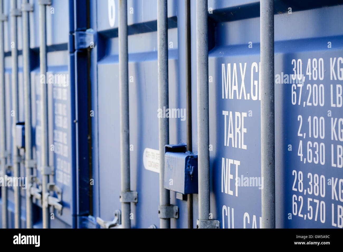 Blue shipping containers showing weights stencilled on the doors Stock Photo Alamy