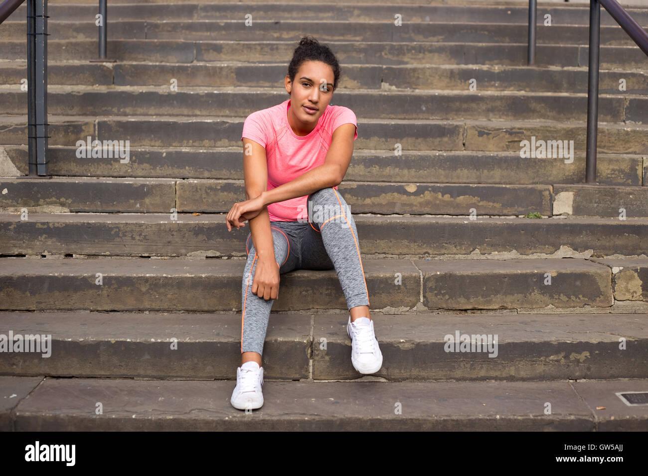 fitness girl having a rest sitting on steps Stock Photo