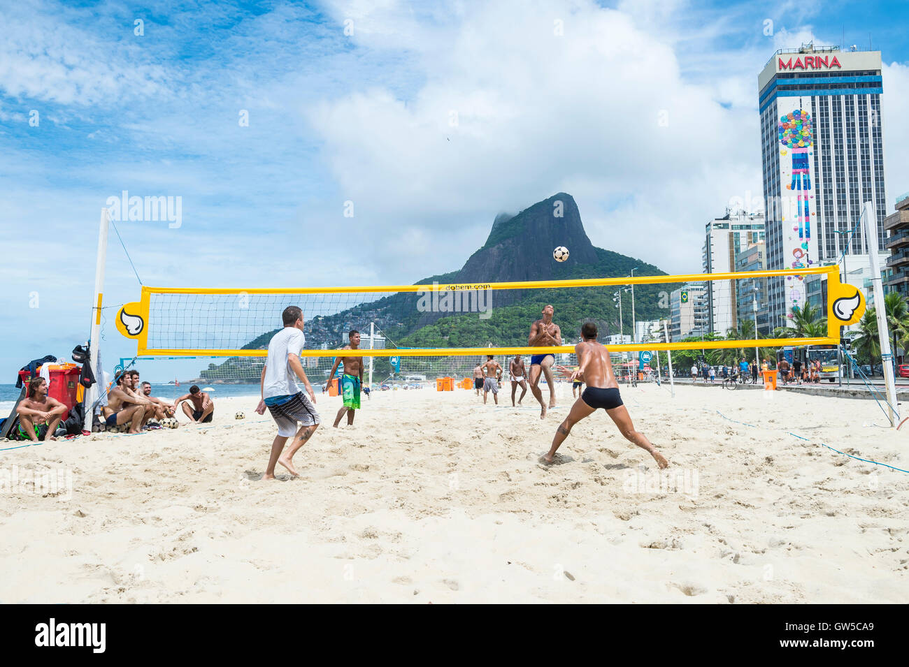RIO DE JANEIRO - MARCH 17, 2016: Young Brazilian men play a game of futevolei (footvolley), a combo of football and volleyball Stock Photo