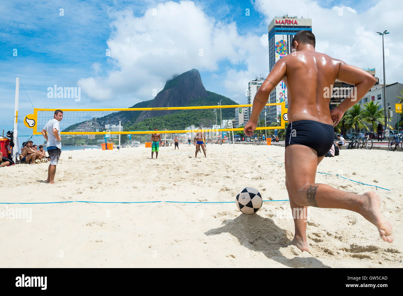 RIO DE JANEIRO - MARCH 17, 2016: Young Brazilian men play a game of futevolei (footvolley), a combination of football and volley Stock Photo