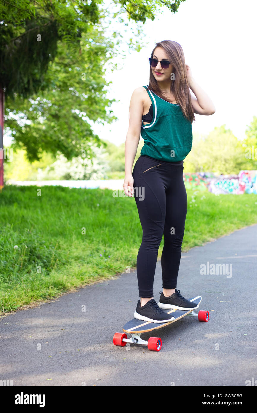 young woman in the park with a longboard Stock Photo