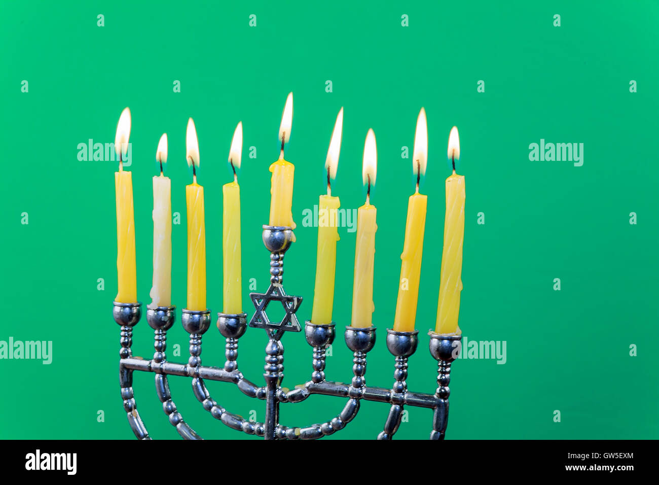 Hanukkah menorah with candles green background isolation Stock Photo