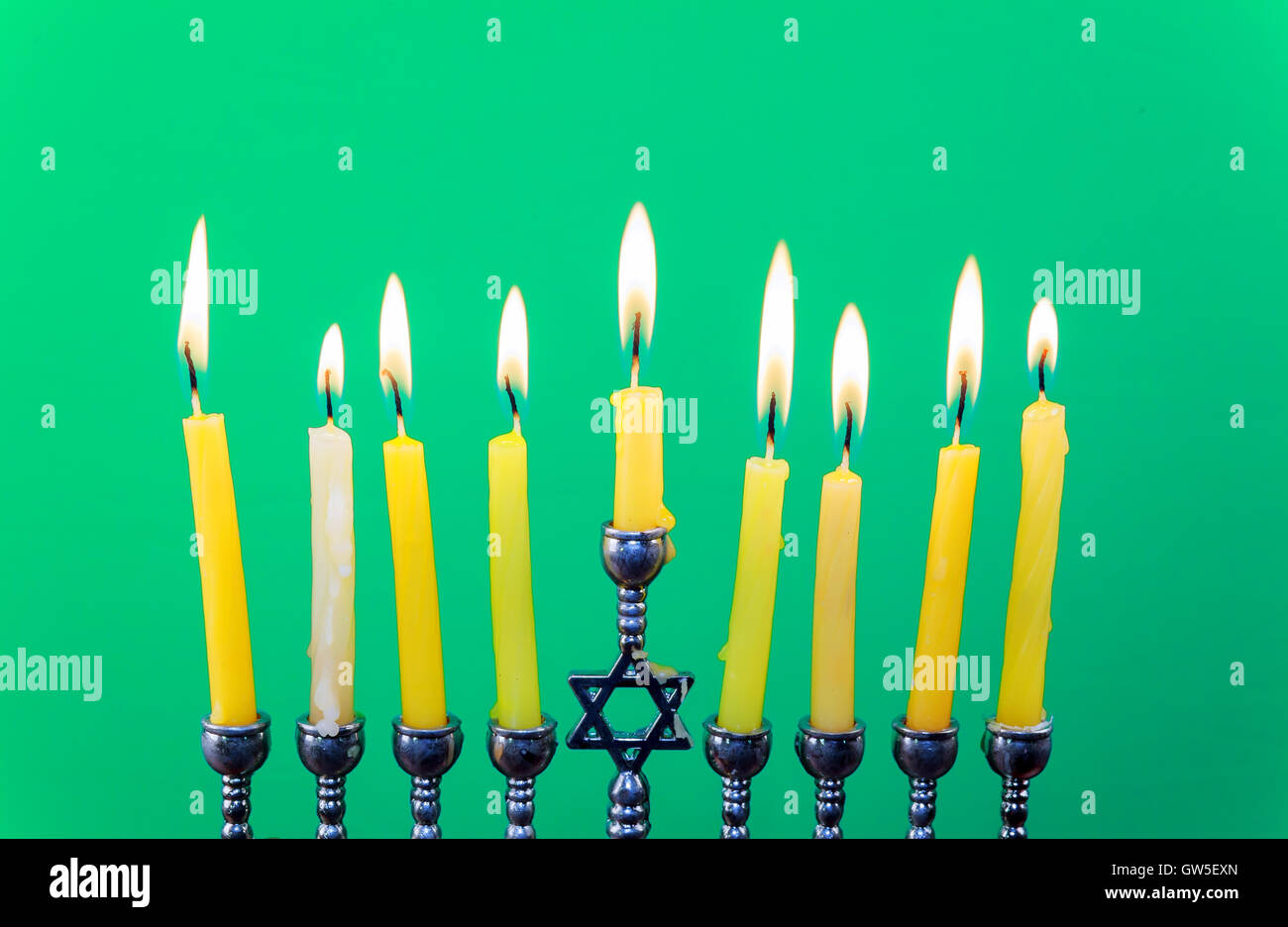 Hanukkah menorah with candles green background isolation Stock Photo