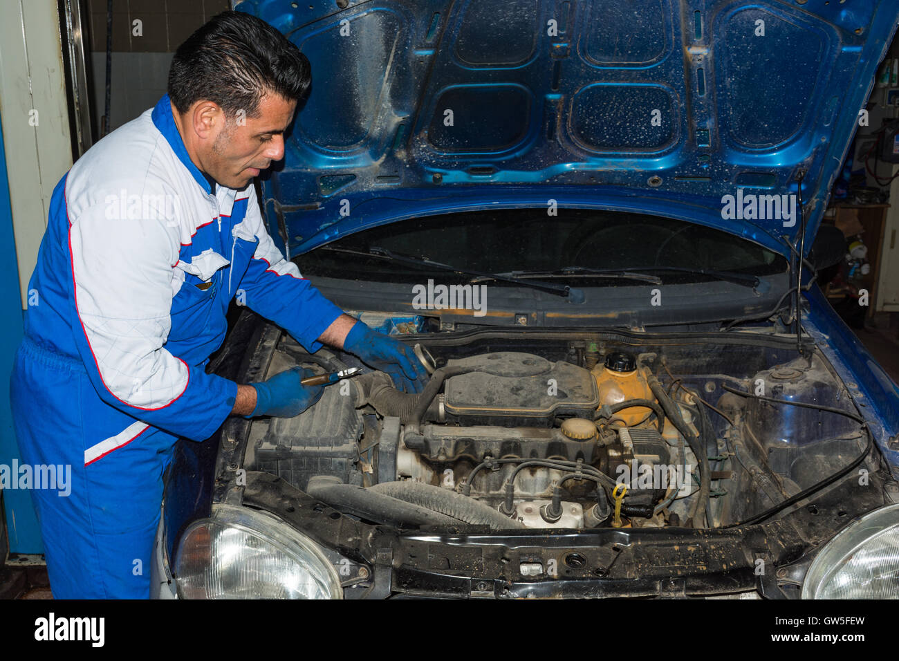 Car mechanic fixing an engine in his garage. copy space Stock Photo - Alamy