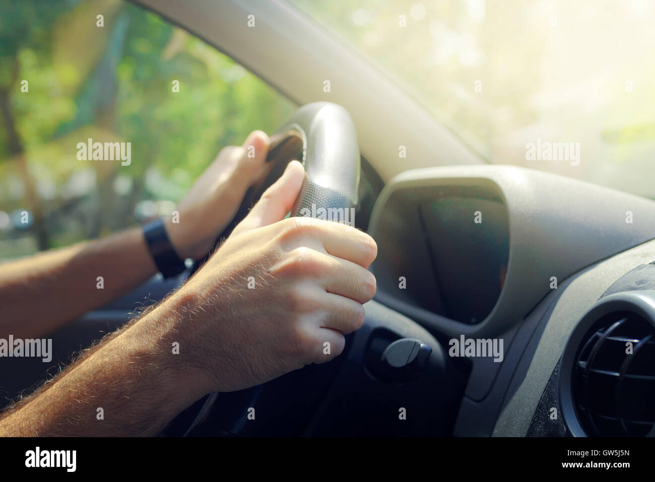 Male hands holding car steering wheel the right way for safe driving Stock Photo