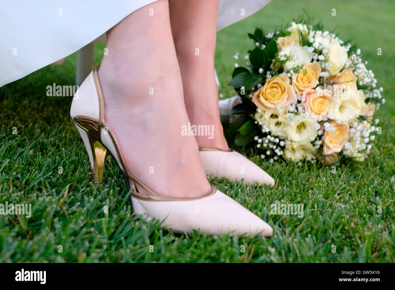 Bridal shoes and flowers bouquet during wedding ceremony Stock Photo