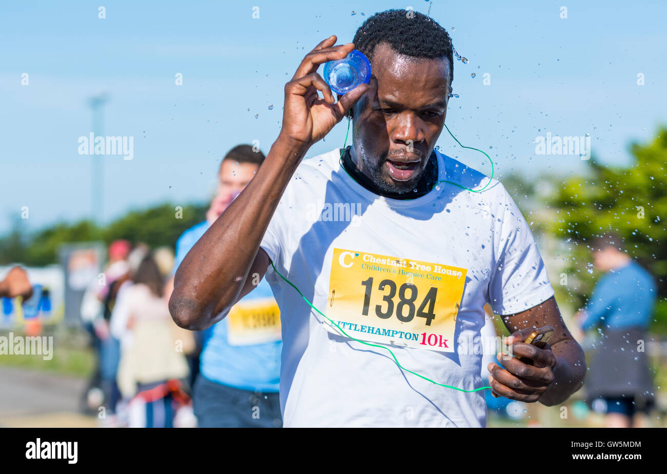 Man cooling off with water while running. Stock Photo