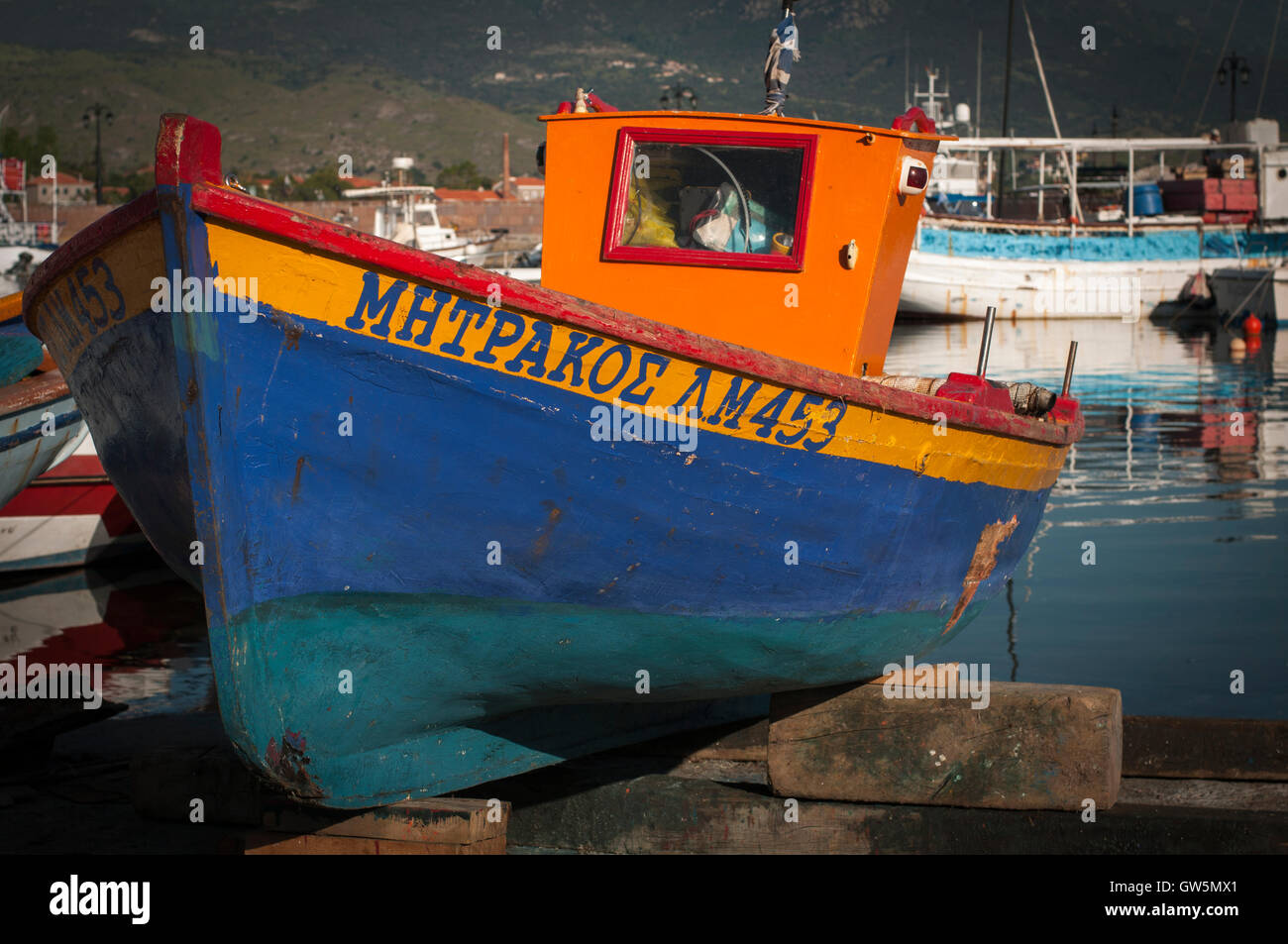 Harbor of a Greek fishing village with fishing boat in drydock with a calm sea Stock Photo