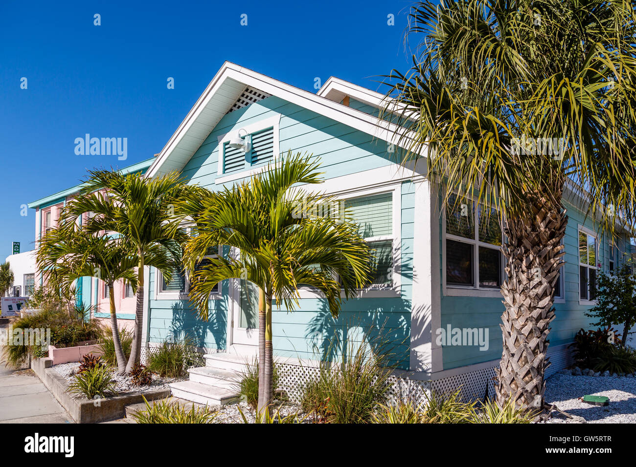 Blue Bungalow and Palm Trees under blue sky Stock Photo - Alamy