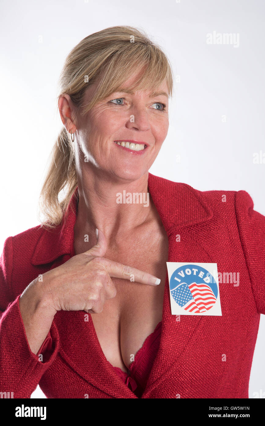Woman points to a election 'I voted'  sticker label attached to her jacket lapel Stock Photo
