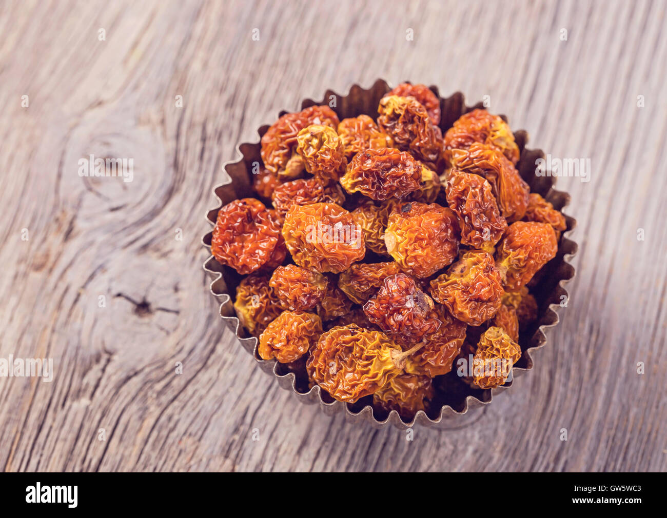 Physalis berries in a bowl on a wooden background Stock Photo