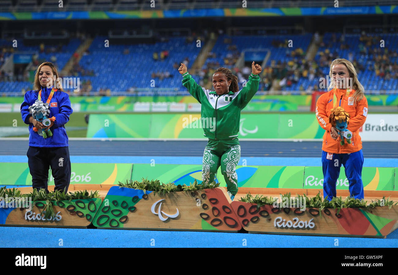 Nigeria's Lauritta Onye (centre) celebrates on the podium after wining the gold medal for the Women's Shot Put - F40 Final, alongside Tunisia's Rima Abdelli (left) who won silver and The Netherlands' Lara Baars who won bronze at the Olympic Stadium during the fourth day of the 2016 Rio Paralympic Games in Rio de Janeiro, Brazil. Stock Photo