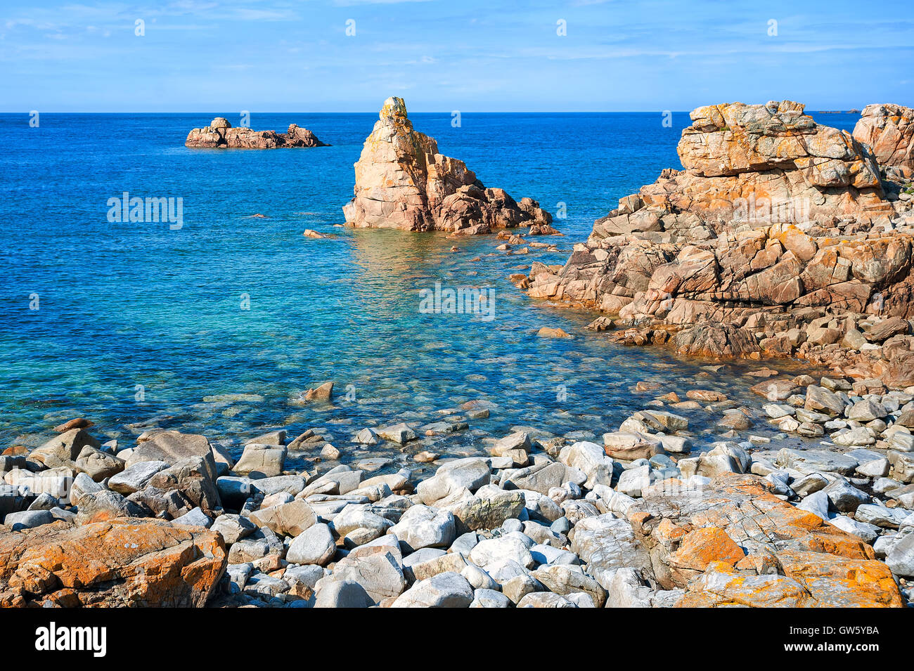 Rocks rising from water at stony beach on Pink Granite Coast, Brittany ...
