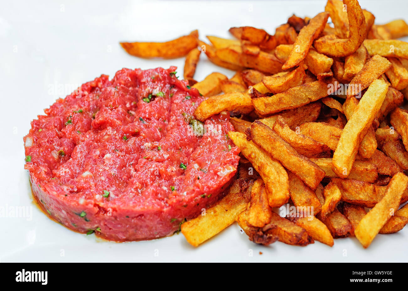 Steak tartare raw minced beef meat served with french fries potato