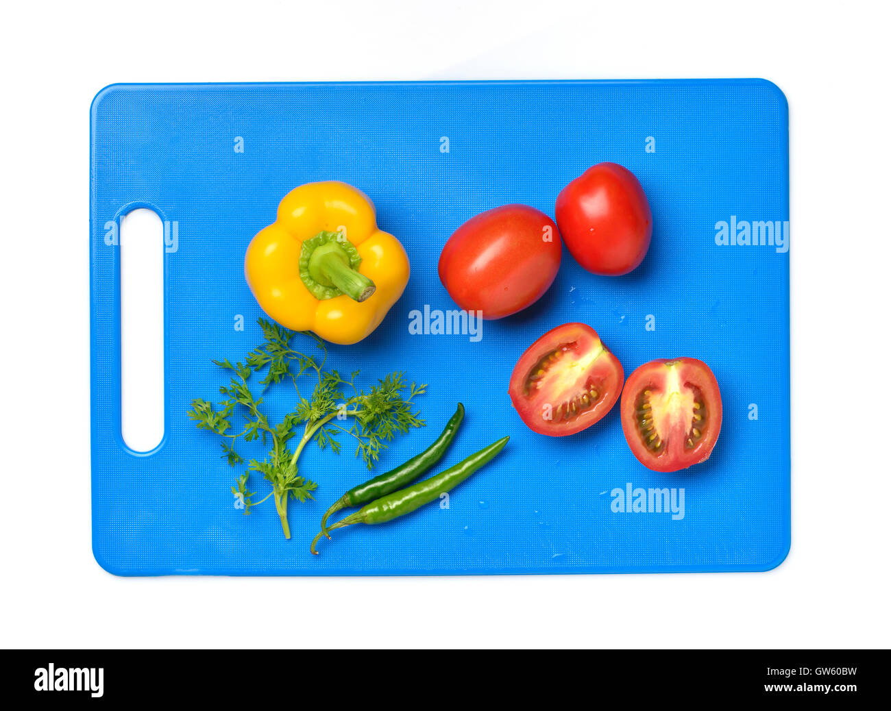 Yellow Bell Pepper, Tomato, Chili And Cilantro on Chopping Board Stock Photo