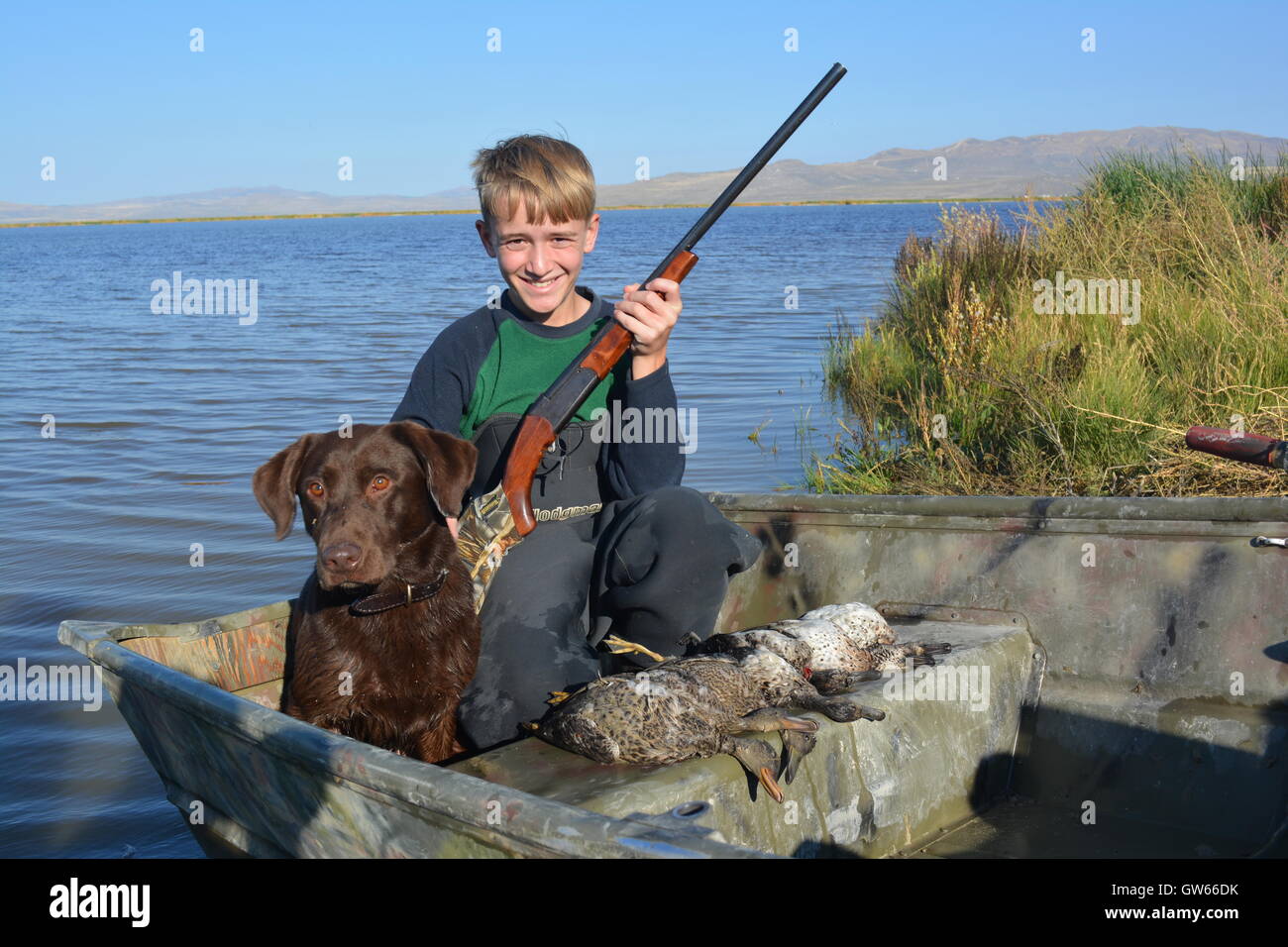 Young boy duck hunter with his dog on the utah youth waterfowl hunt