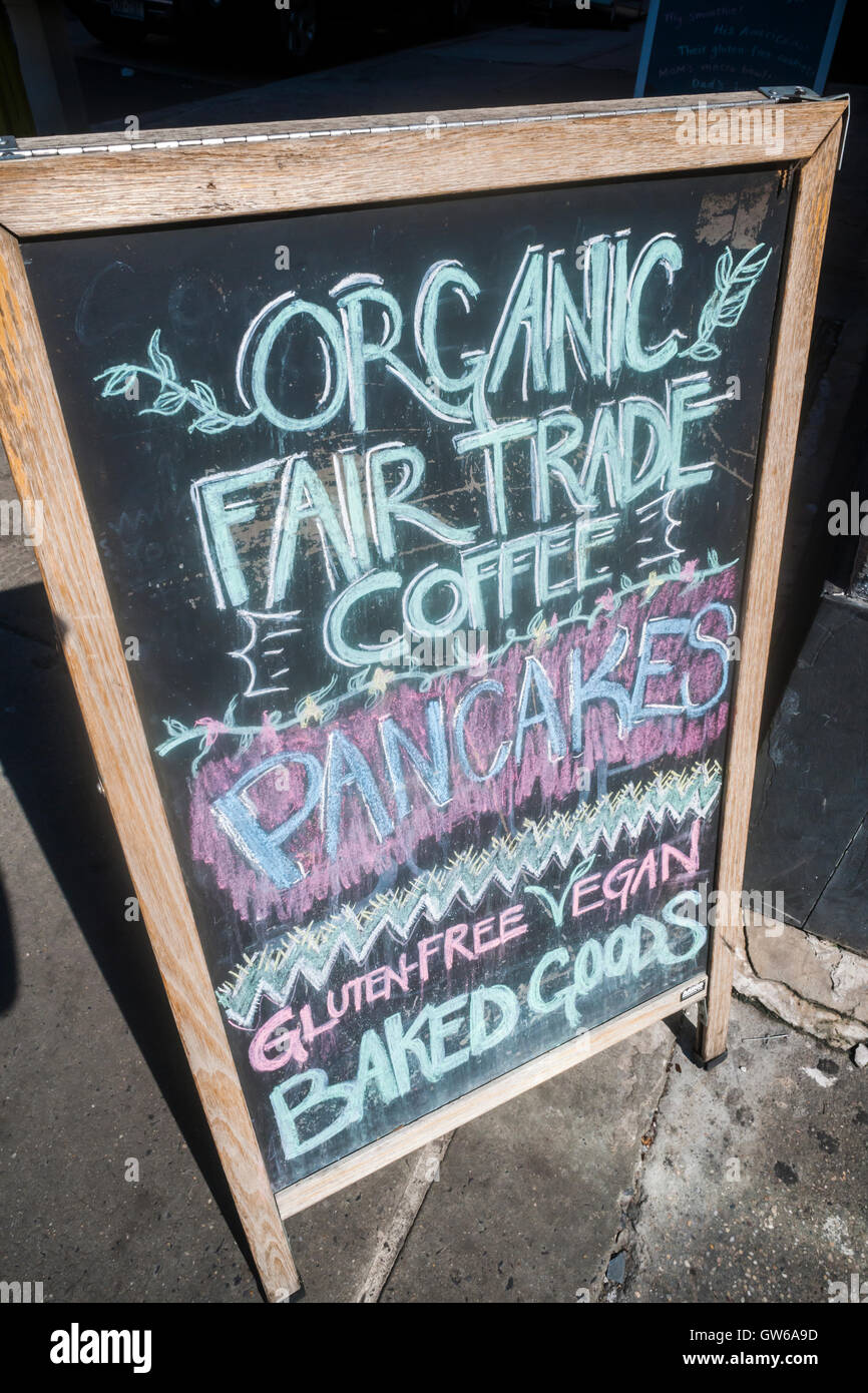 A sign outside of a restaurant in New York on Sunday, September 4, 2016 promotes their vegan, organic, fair trade and gluten-free offerings, as well as pancakes. The protein gluten is found in wheat and is a flavoring and thickening food additive. People with celiac disease, dermatitis herpetiformis  and wheat allergies eat a gluten-free diet to prevent their disease or allergy. (© Richard B. Levine) Stock Photo