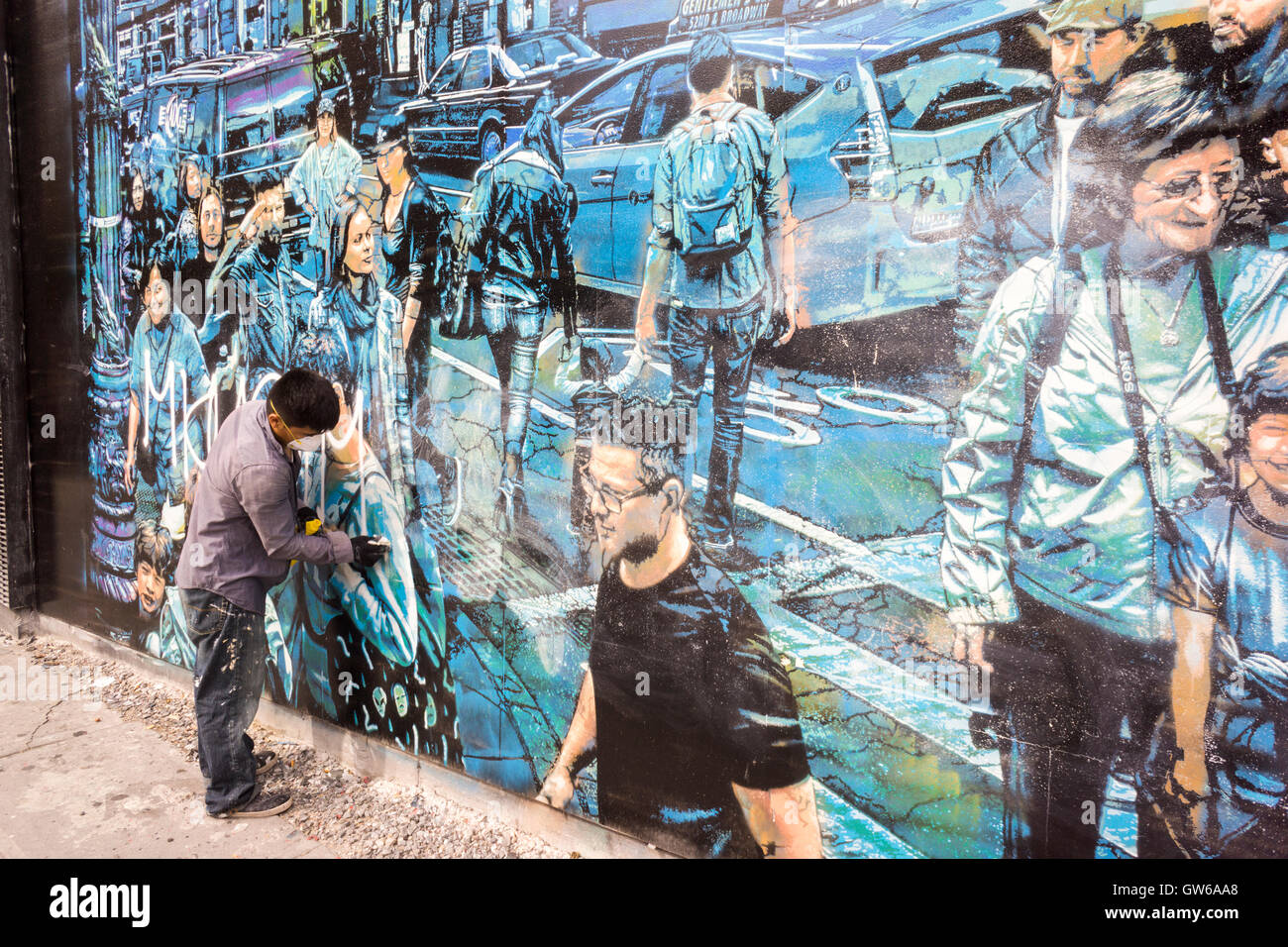 A worker cleans off vandalism on the new mural, entitled 'Story Of My Life' by renowned street artist Logan Hicks on the Bowery & Houston mural wall in Soho in New York on Saturday, September 3, 2016. The space is owned by Goldman Properties and has been hosting murals for an untold amount of years. (© Richard B. Levine) Stock Photo