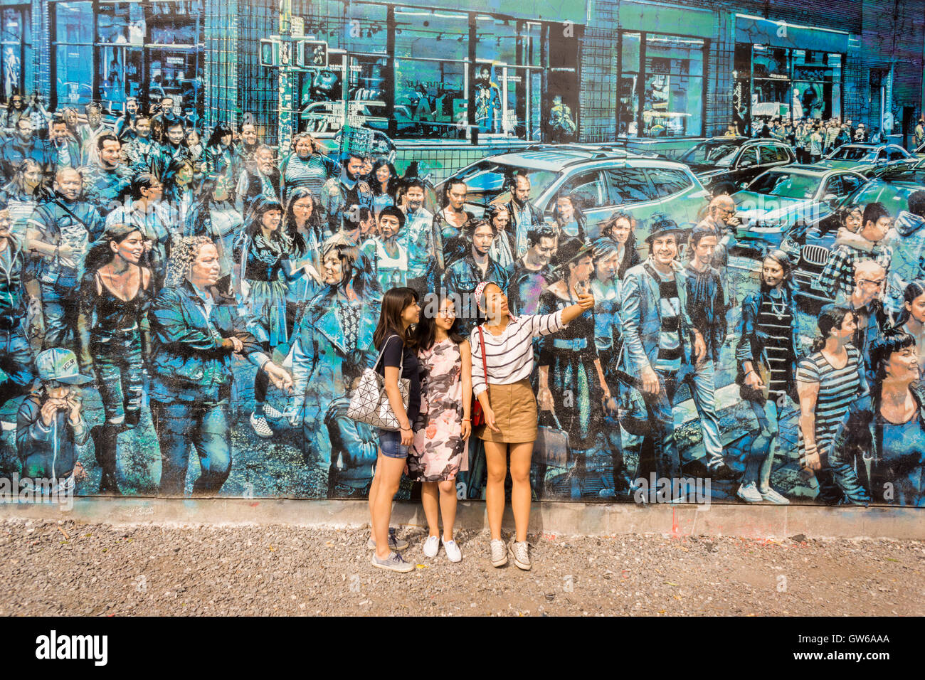 Passer-by admire the new mural, entitled 'Story Of My Life' by renowned street artist Logan Hicks on the Bowery & Houston mural wall in Soho in New York on Saturday, September 3, 2016. The space is owned by Goldman Properties and has been hosting murals for an untold amount of years. (© Richard B. Levine) Stock Photo
