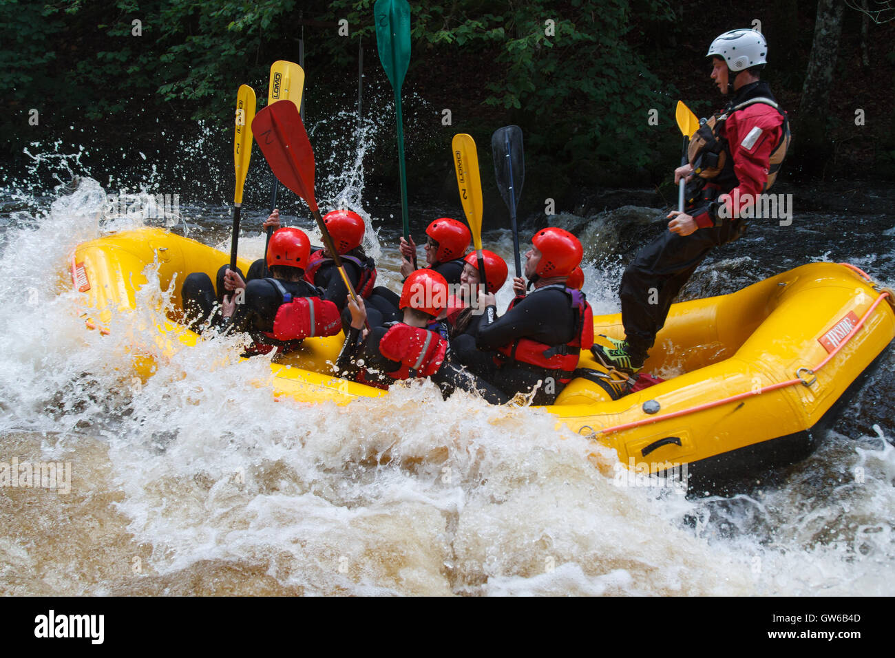 White water raft being tossed in the rapids at the National White Water Centre on the River Tryweryn outside Bala North Wales Stock Photo