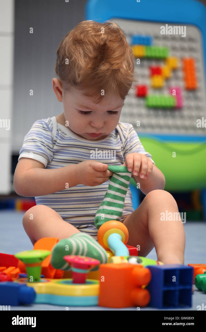 A funny baby boy trying to dress socks Stock Photo - Alamy