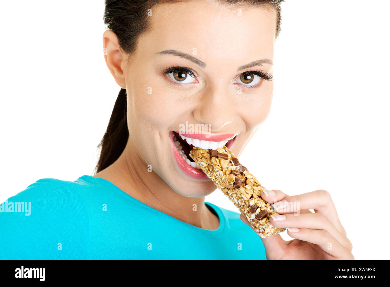 Young woman eating cereal candy bar Stock Photo